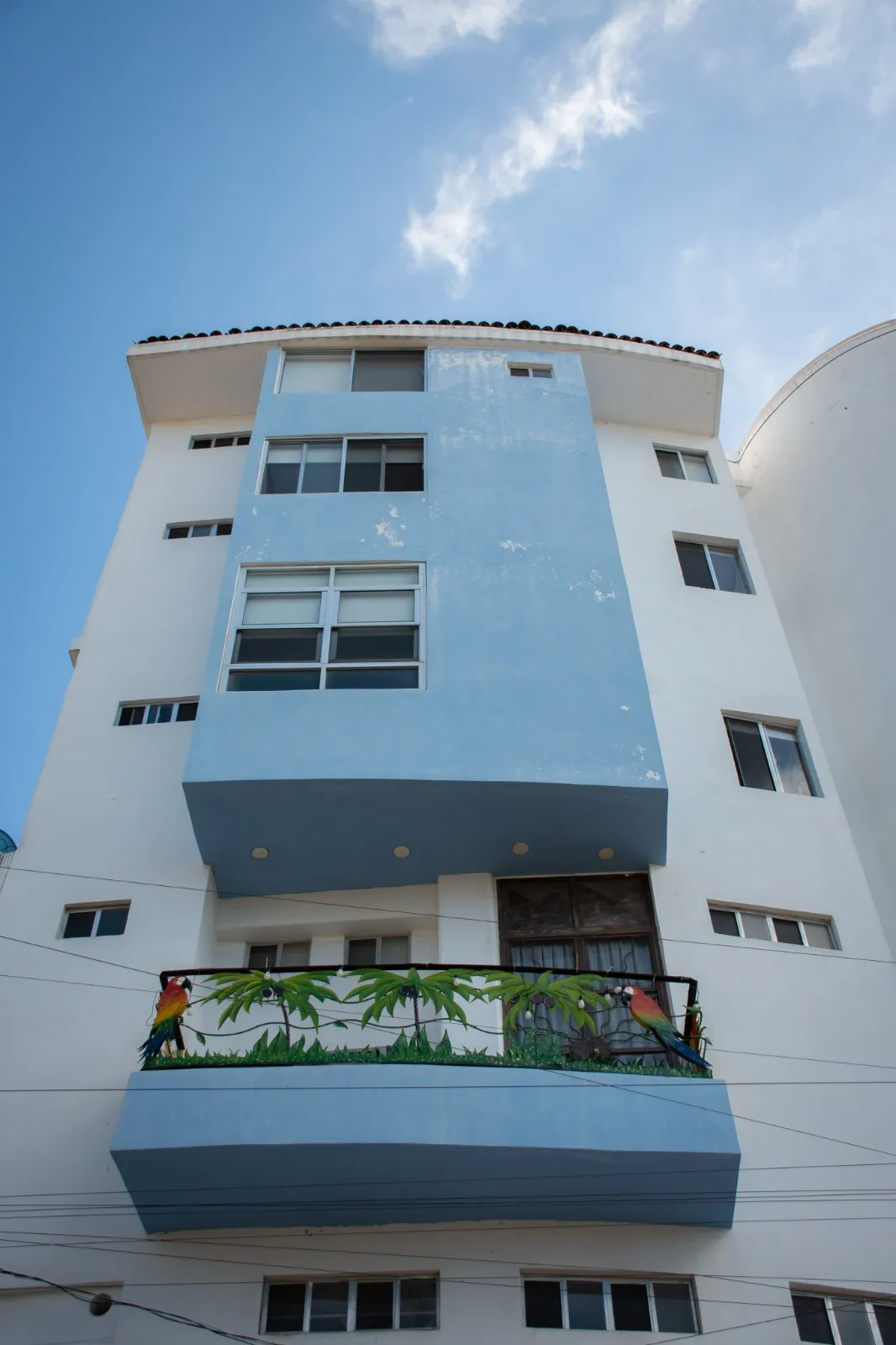 Fachada blanca y azul con balcones del Edificio Chévere