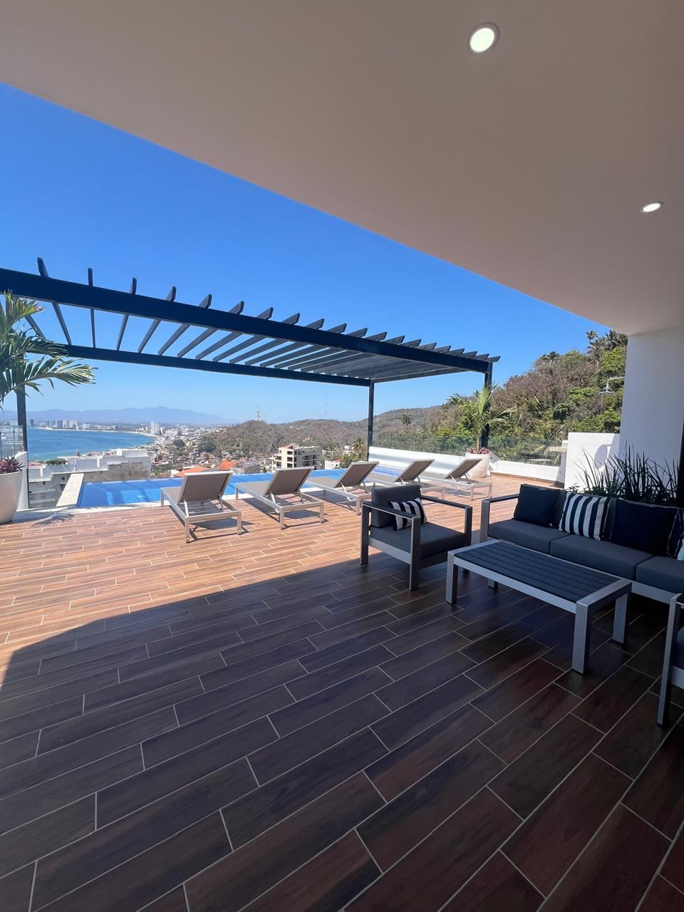 Terraza techada con sala exterior y vista a la bahía